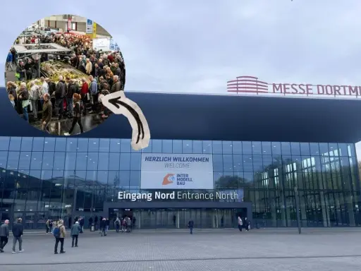 Besucher strömen zur Intermodellbau Messe in Dortmund. Ein kleiner Kreis zeigt die belebte Halle mit vielen Ausstellungsstücken.