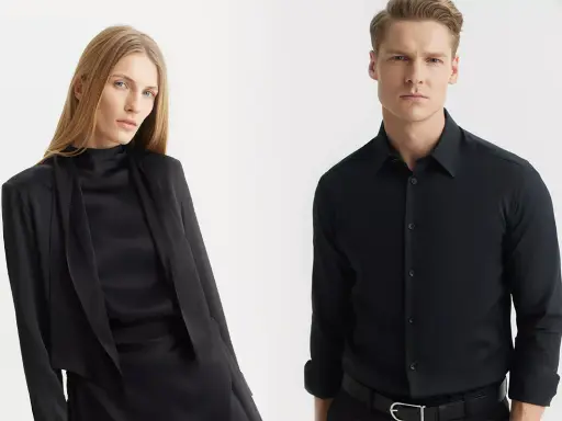 Elegancka kobieta w czarnej stylizacji i mężczyzna w czarnej koszuli męskiej, prezentujący klasyczne, ponadczasowe zestawy.