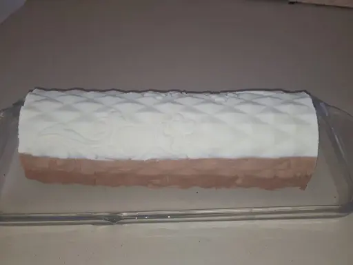Un biscuit croustillant pour entremet, avec un décor en relief, est présenté dans un plat en verre.