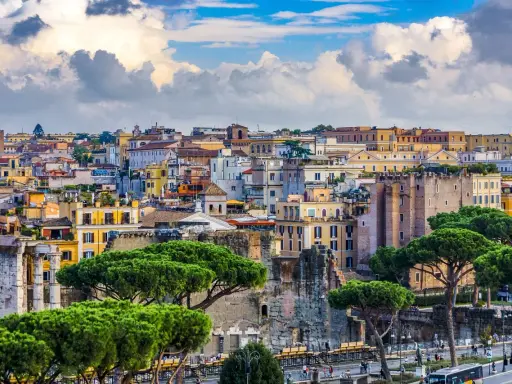 Vista panorámica de Roma con edificios históricos y pinos. Jóvenes exploran la ciudad eterna, disfrutando de su belleza.
