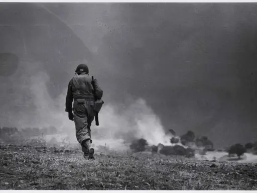 Soldato solitario cammina verso il fumo di battaglia, un'iconica immagine di Robert Capa.