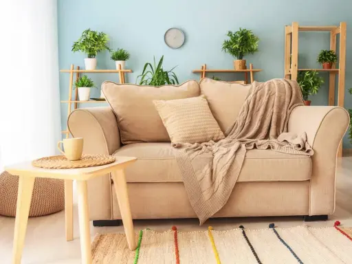 Un plaid douillet drapé sur un canapé beige, invitant à la détente. Idéal pour savoir comment mettre un plaid sur un canapé avec style.