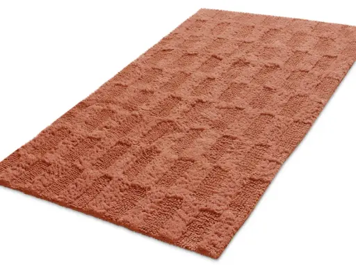 En mjuk, orange badrumsmatta med ett rutmönster. Den ger en varm och inbjudande känsla.