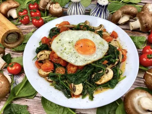 Herzhaftes Gericht mit Baby Spinat, Tomaten, Pilzen und Spiegelei. Perfekt für gesunde Baby Spinat Rezepte.