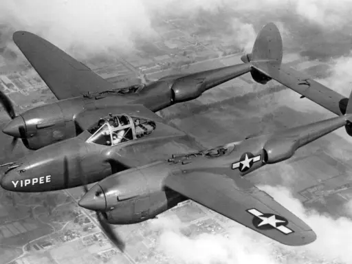 Ein P-38 Flugzeug mit dem Namen "YIPPEE" fliegt über Wolken.