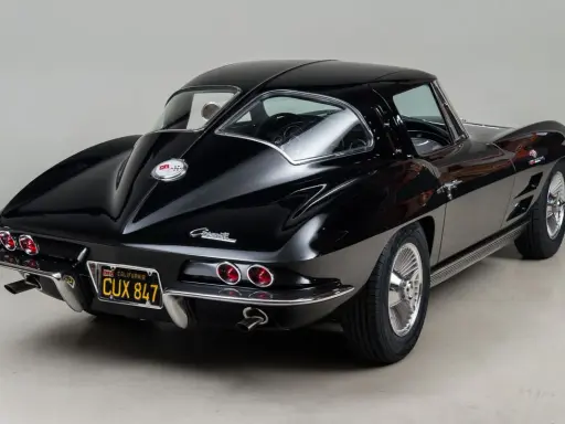 Un clásico Corvette Stingray negro, un ícono de los muscle cars americanos, con su distintiva silueta y detalles cromados.