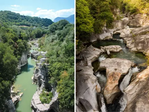 Gole scavate dall'acqua tra le verdi marche montagna. Un fiume serpeggia tra rocce levigate e vegetazione lussureggiante.