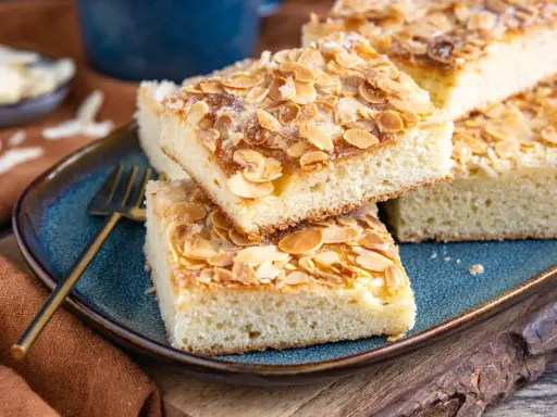 Saftige Stücke Butterkuchen mit Mandelblättchen und Zucker bestreut, bereit zum Genießen. Ein köstliches Rezept für jeden Anlass.