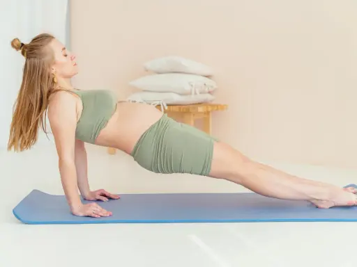 Gravid kvinna i yinyoga-position på matta, med fokus på lugn och styrka under graviditeten.