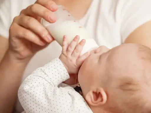 Dziecko pije mleko modyfikowane z butelki. Karmienie to może mieć różne konsekwencje dla rozwoju malucha.