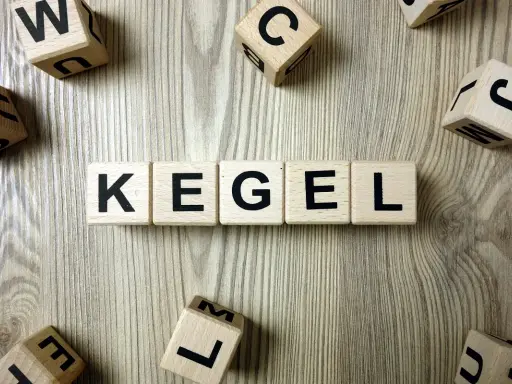 Drewniane klocki z literami układają słowo "KEGEL". Ćwiczenia mięśni Kegla u kobiet to klucz do zdrowia.