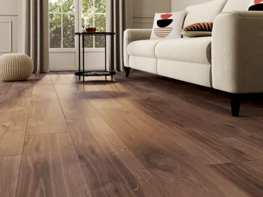 Un salon lumineux avec un nouveau revêtement sol en bois chaleureux, un canapé crème et des coussins décoratifs.