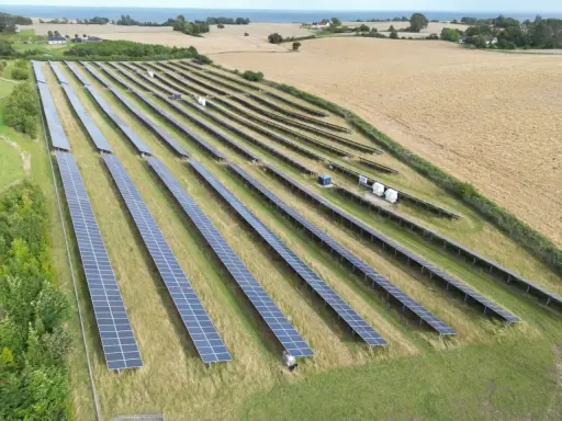 Stora fält med solceller i ett lantligt landskap, med havet i bakgrunden. Spännande solceller nyheter för framtiden.