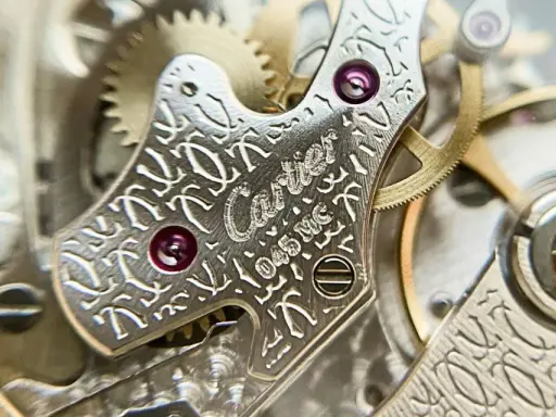 Dettaglio del movimento di un orologio Cartier, con incisioni guilloché e rubini. La joux perret, un capolavoro di precisione.