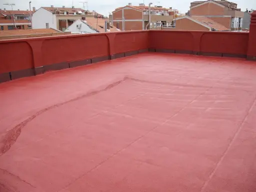 Tejado con acabado rojo, recién aplicado un slurry que es una capa protectora.