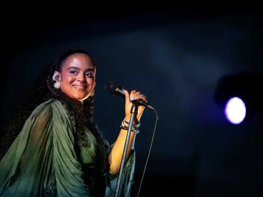 Seinabo Sey njuter av att uppträda på en konsert, med ett leende och mikrofonen i handen.