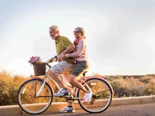 Pareja mayor disfruta de un paseo en bicicleta, celebrando la jubilación a los 61 años con la nueva reforma.