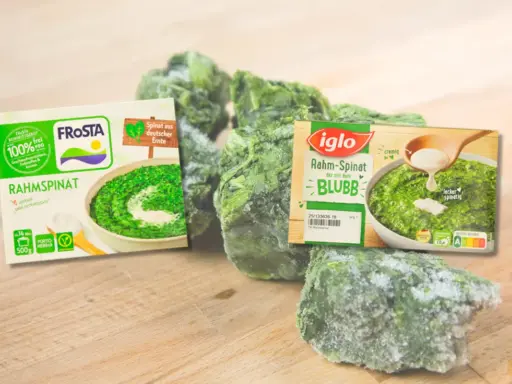 Gefrorener Rahmspinat von Frosta und Iglo, reich an Spinat Protein, liegt auf einem Holzbrett.