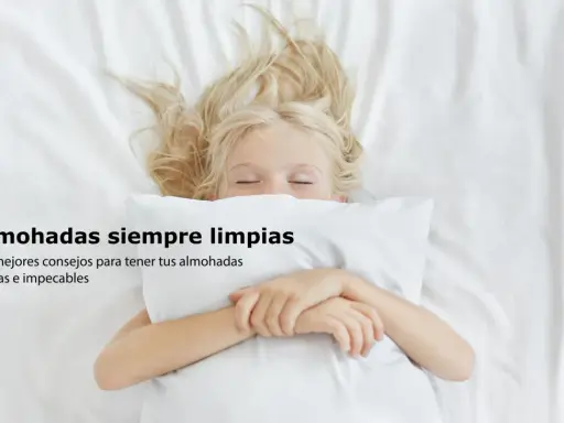 Niña rubia duerme abrazada a una almohada blanca. Consejos sobre como lavar almohadas para que estén frescas e impecables.