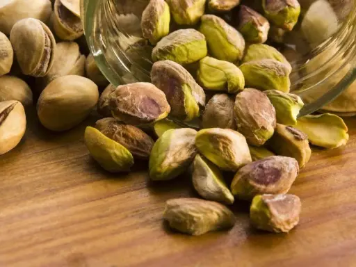Garść pistacji wysypana ze słoika. Czy pistacje są kaloryczne? Tak, ale zdrowe!