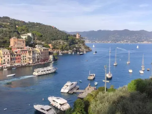 Colorati paesi della Riviera di Levante, con barche a vela e yacht che solcano il mare blu.