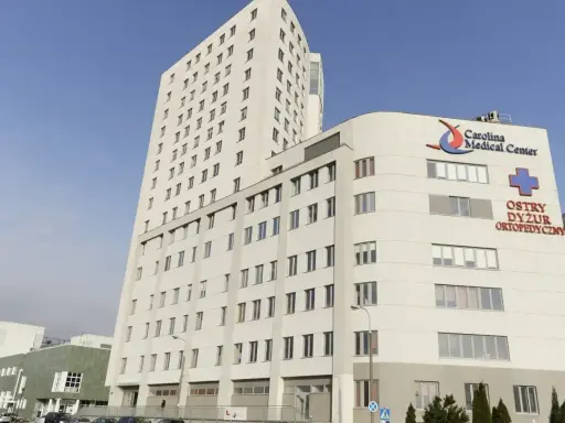 Nowoczesny budynek Carolina Medical Center w Warszawie z napisem "Ostry Dyżur Ortopedyczny".