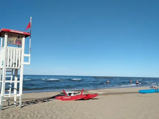 Torre di salvataggio e barchini sulla spiaggia di Rimini, pronti per nuove storie di mare.