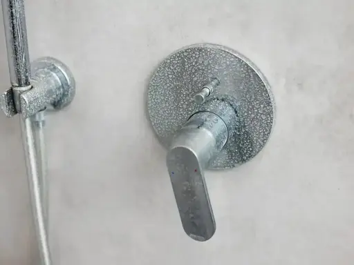Mitigeur thermostatique de douche entartré, prêt à démonter sans vis. Le levier est en position basse.