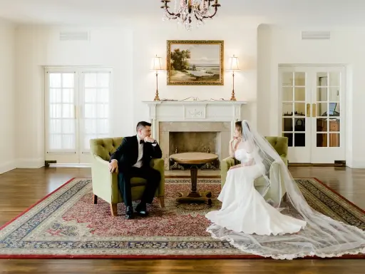 Para młoda siedzi naprzeciwko siebie w eleganckich fotelach, przeżywając ostatnie chwile przed ślubem.