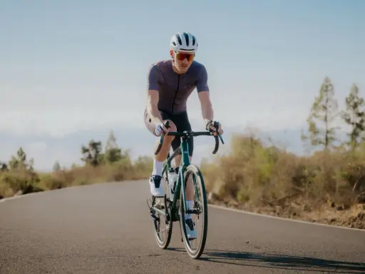 Radfahrer auf einer Straße, der die Prinzipien der **Superkompensation im Sport** verkörpert.