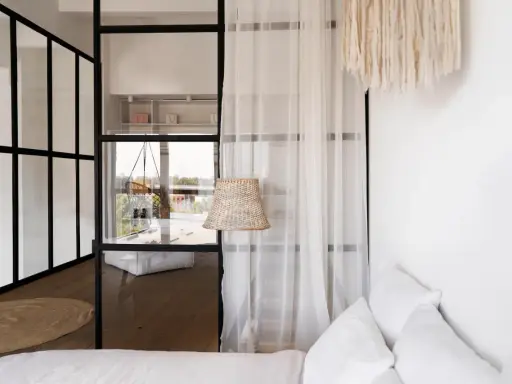 Verre et métal séparent la chambre en deux, avec une seule fenêtre offrant une vue sur l'extérieur. Un rideau léger ajoute de la douceur.