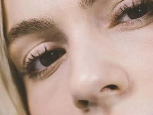 Primer plano de un ojo y nariz de mujer rubia. Consejos sobre como disimular las bolsas de los ojos.