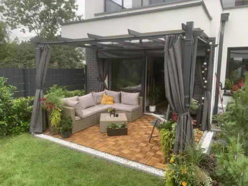 Nowoczesna pergola w ogrodzie z wygodnym narożnikiem i stolikiem. Idealne miejsce na relaks i inspiracje.