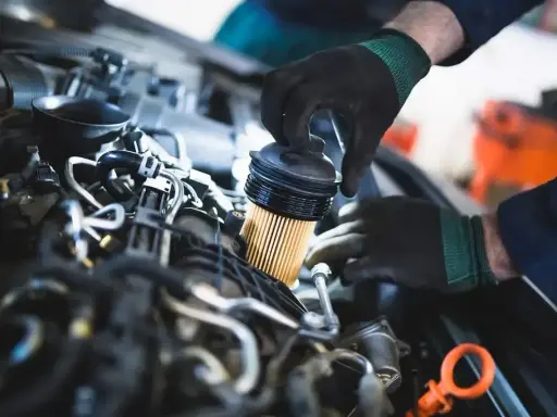 Mechanik wymienia filtr paliwa. Objawy jego zużycia mogą być różne, od spadku mocy po problemy z uruchomieniem silnika.