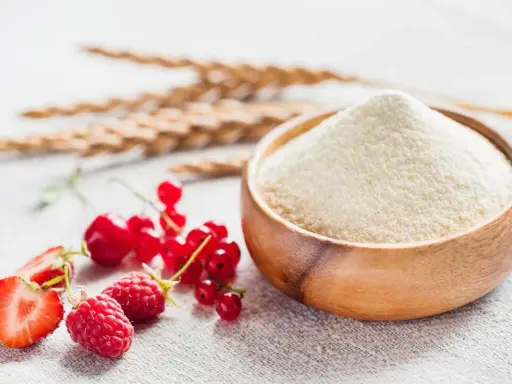 Miseczka pełna semoliny, obok świeże maliny, truskawki i porzeczki. Semolina co to? Mąka z pszenicy durum.