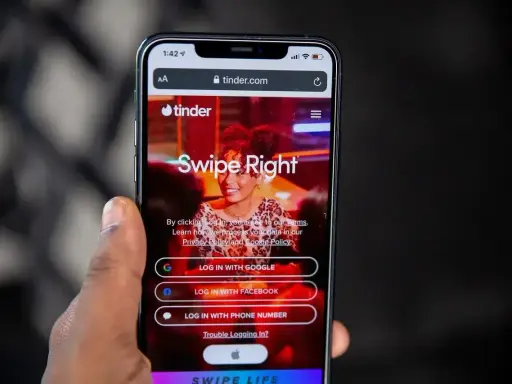 Ekran logowania Tindera z opcjami "Swipe Right", "Log in with Google", "Log in with Facebook" i "Log in with phone number". Szybkie skróty na Tinderze ułatwiają rozpoczęcie randkowania.