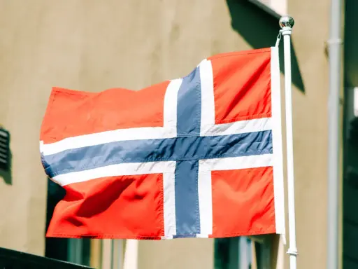 Flaga Norwegii powiewa na wietrze. Myśląc o tym kraju, często zastanawiamy się nad jego gospodarką, czyli **norwegia brutto netto**.