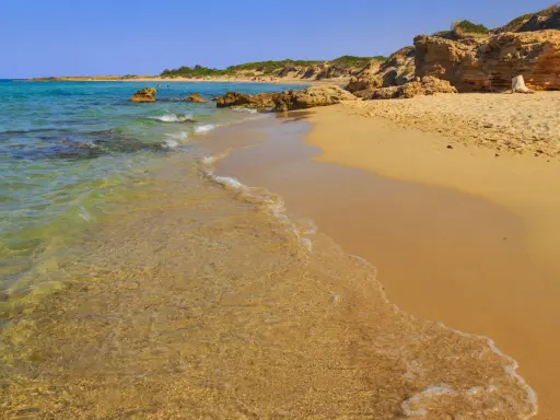 Spiagge libere in Puglia: sabbia dorata, acque cristalline e scogliere naturali. Un angolo di paradiso per godersi il sole e il mare.