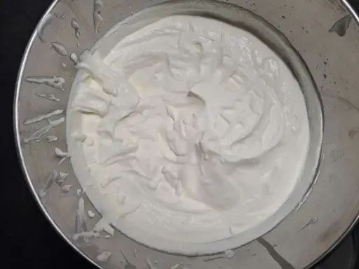 Crème diplomate mascarpone onctueuse dans un bol en métal, prête à garnir un dessert.
