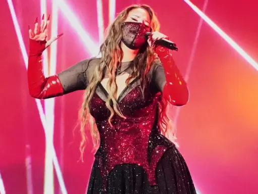 Artist med mask och röda handskar sjunger på scen. Kanske en försmak av Eurovision 2026 tid?