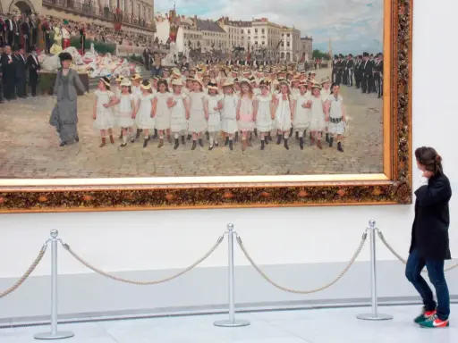Una mujer observa un cuadro de niños desfilando en los Museos Reales de Bellas Artes de Bélgica.