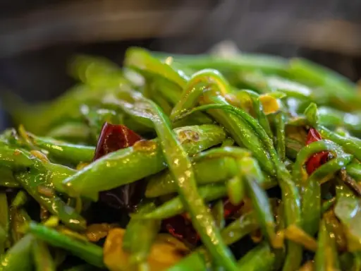 Haricots verts sautés avec des piments rouges, un plat simple et savoureux, parfait pour une recette haricot vert rapide.