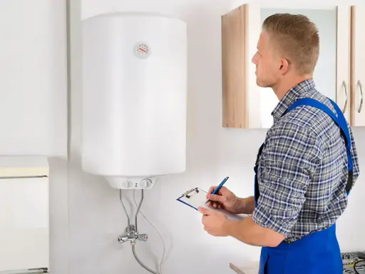 Técnico revisa un termo eléctrico que gotea, anotando en su portapapeles.