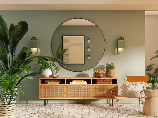 Ingresso accogliente con piante rigogliose, mobile in legno con rattan e un'opera d'arte astratta. La parete verde crea una **tabella colori caldi** rilassante.