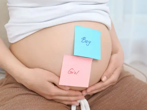 Brzuszek ciężarnej z karteczkami "Boy" i "Girl". Czy płeć dziecka może się zmienić?
