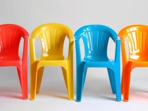 Cztery kolorowe krzesła: czerwone, żółte, niebieskie i pomarańczowe. Idealne na zewnątrz, jaka farba do plastiku na zewnątrz sprawdzi się najlepiej?
