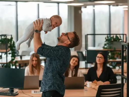 Szczęśliwy ojciec podrzuca dziecko w biurze, gdzie pracują kobiety. Czy urlop wychowawczy wlicza się do stażu pracy?