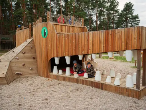 Dwa chłopcy bawią się w drewnianym potworze, jednej z atrakcji w Lubinie.