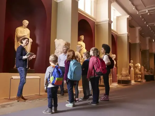 Un grupo de niños disfruta de las exposiciones en un museo de Madrid, aprendiendo sobre arte e historia con su guía.