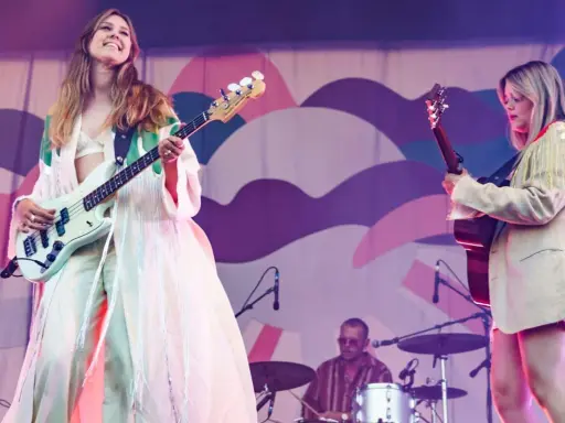 Kvinnlig basist och gitarrist uppträder på en konsert. Bakom dem sitter en trummis. En **first aid kit konsert** kan vara bra att ha nära till hands.